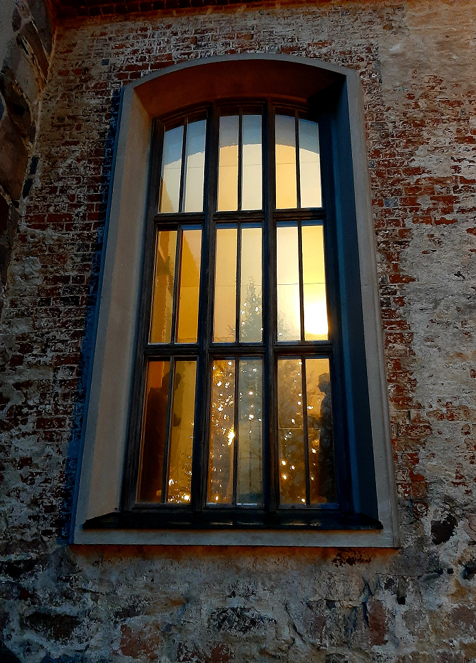 Ett fönster från kyrkan med belysningen på inom hus